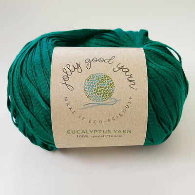 Yellow yarn ball with a label on a light gray background