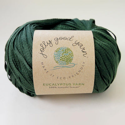 Yellow yarn ball with a label on a light gray background
