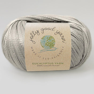 Yellow yarn ball with a label on a light gray background