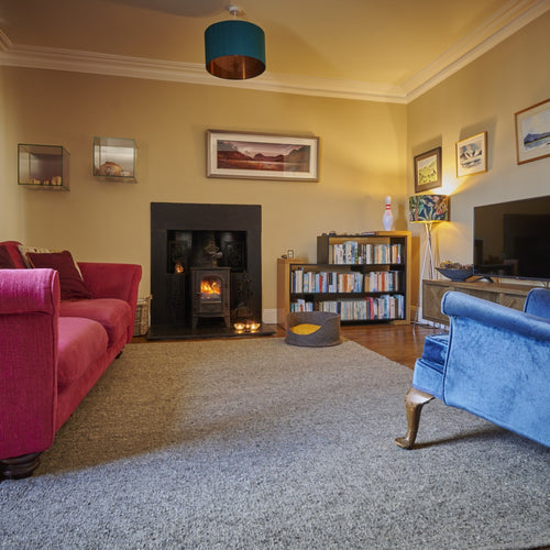 Large wool rug in traditional living room with felt pet bed