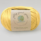 Yellow yarn ball with a label on a light gray background