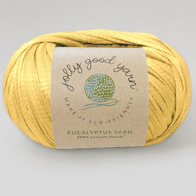 Yellow yarn ball with a label on a light gray background