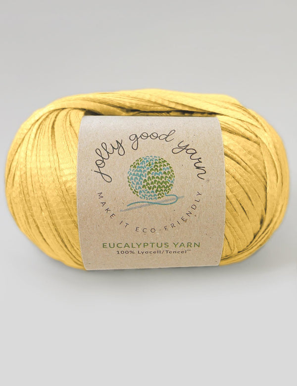 Yellow yarn ball with a label on a light gray background