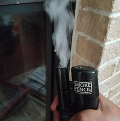 smoke pencil emitting a plume of smoke being used to detect draughts thumbnail