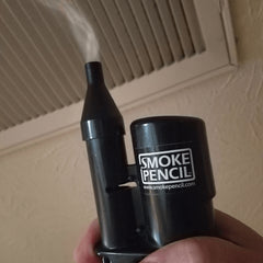 smoke pencil emitting a plume of smoke being used to detect draughts thumbnail