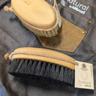 Two brushes with natural bristles on a denim background, featuring the 'natural by hillbrush' brand.