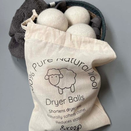 &Keep 100% Natural Dryer Balls pouring out of their bag into a bowl with a towel in 