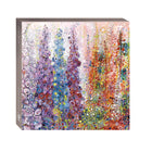 A square card box featuring an abstract floral painting with tall purple, blue, and orange flower-like forms on a light background. The box is shown at a slight angle against a plain white background.