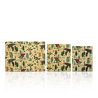 Three rectangular beeswax wraps  with an all-over jungle animal print, arranged in descending size on a white reflective surface.