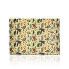 A rectangular beeswax wrap, featuring a whimsical woodland safari pattern with animals like elephants, giraffes, lions, and zebras on a light beige background. The wrap is displayed flat against a white background with a soft reflection underneath.