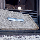 Close up of a grey wool removeable chimney blocker with a safety tag visible in the background.