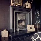 A removable chimney draught excluder sat at the side of a fireplace so the fire can be turned on. This will be able to be reinserted into the open chimney flue once the fire has been turned off.